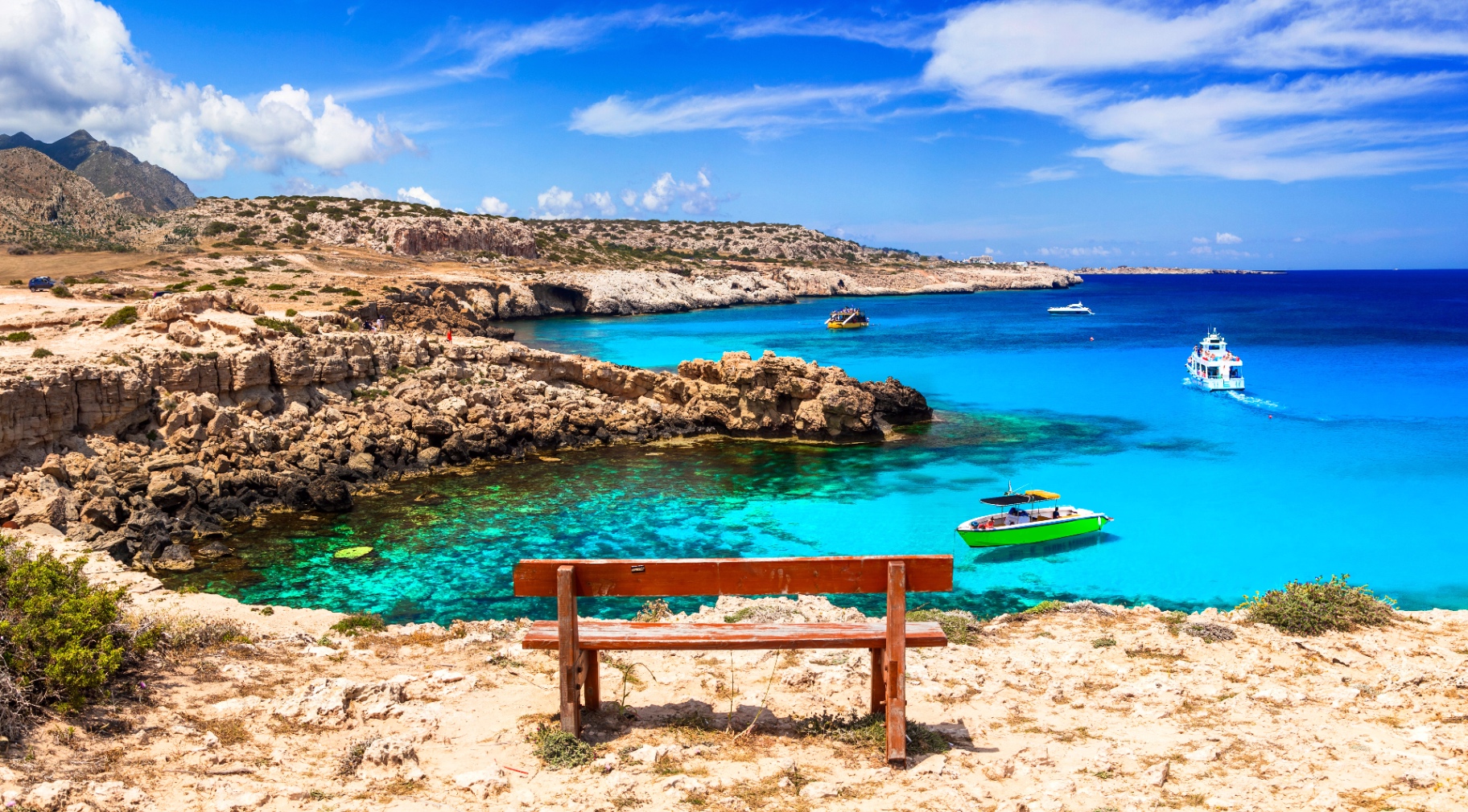 Wooden bench overlooking turquoise Mediterranean cove, clarity and perspective